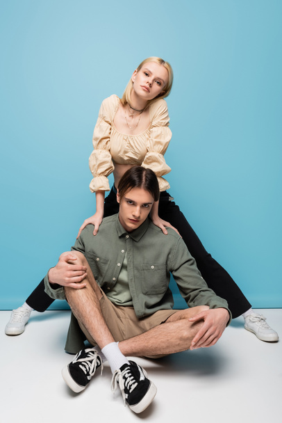 Stylish young couple in sneakers posing on blue background - Foto, immagini