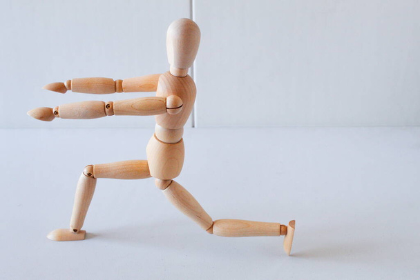 Wooden doll as a model for exercising in a healthy life - Foto, afbeelding