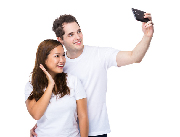 Asian woman and caucasian man take selfie together - Photo, image