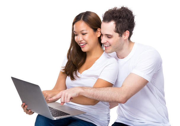 Couple using laptop together - 写真・画像