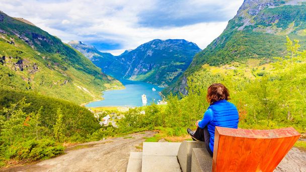 Tourism vacation and travel. Female tourist enjoying beautiful view over magical Geirangerfjorden from Flydalsjuvet viewpoint, Norway. Tourist attraction. - Fotoğraf, Görsel