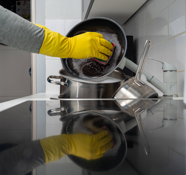 Washing dishes while cleaning the house. Kitchen cleaning. Dirty dishes. - 写真・画像