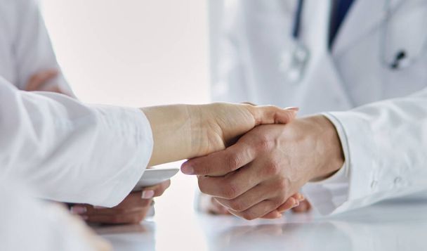 Doctor shaking hands with a male patient in the office. - Foto, imagen