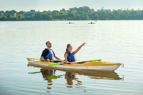 a young couple is kayaking on a pond, water tourism, active recreation - Φωτογραφία, εικόνα
