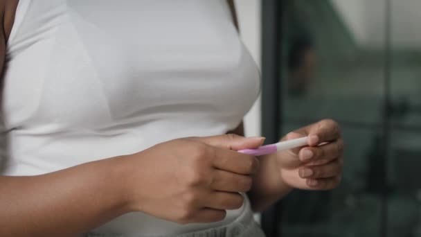 Detail van handen van onherkenbare Afro-Amerikaanse gestresste vrouw wachtend op zwangerschapstest resultaten. Opgenomen met RED helium camera in 8K.     - Video