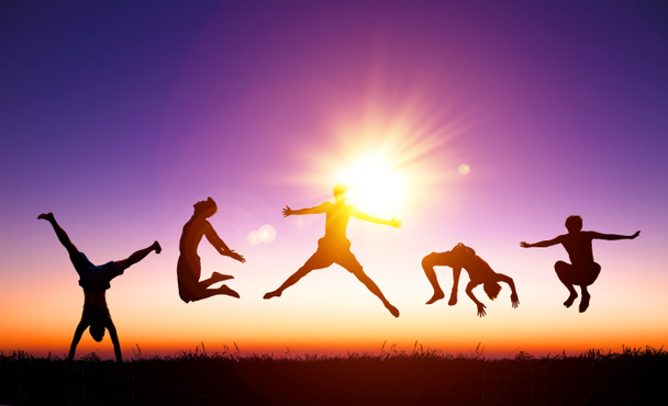 happy young people jumping on the hill with sunlight background - Foto, Bild