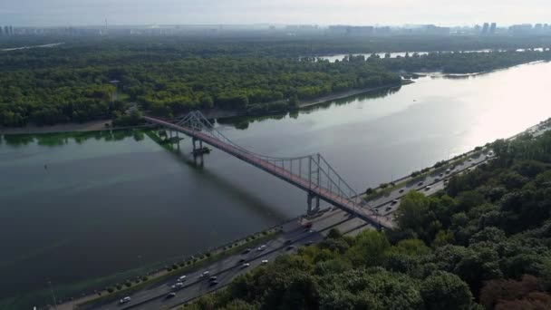 Drone vista aérea Kyiv puente peatonal, la isla de Truchaniv y el río Dniéper en un hermoso día soleado de primavera. Capital de Ucrania - Metraje, vídeo