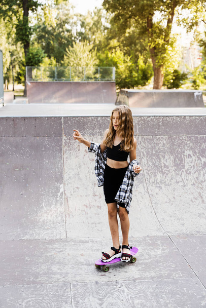 Criança menina passeio em penny board ou skate board. Equipamento desportivo para crianças. Adolescente com placa de centavo no parque de skate - Foto, Imagem