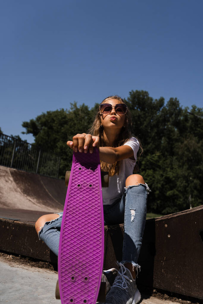 Active child with penny board sitting on skate sport ramp. Extreme sport lifestyle. Creative advertising for sports children store - Foto, Imagem