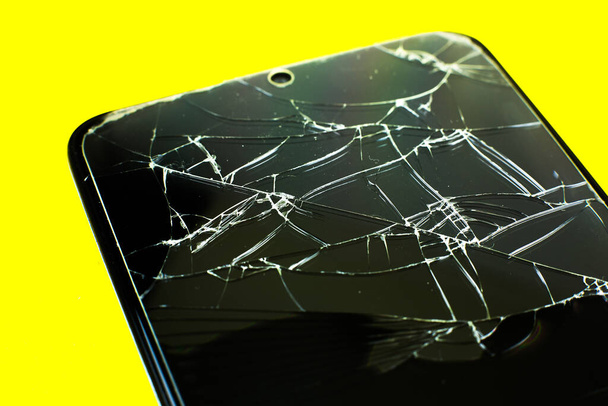 Broken tempered glass screen protector. Crashed smartphone. Close up. - Photo, image