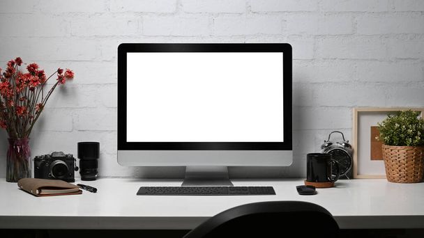 Kreativer Arbeitsplatz mit Computer, Kamera, Notizbuch und Zimmerpflanze auf Holztisch. Leere Anzeige für Ihren Anzeigentext. - Foto, Bild