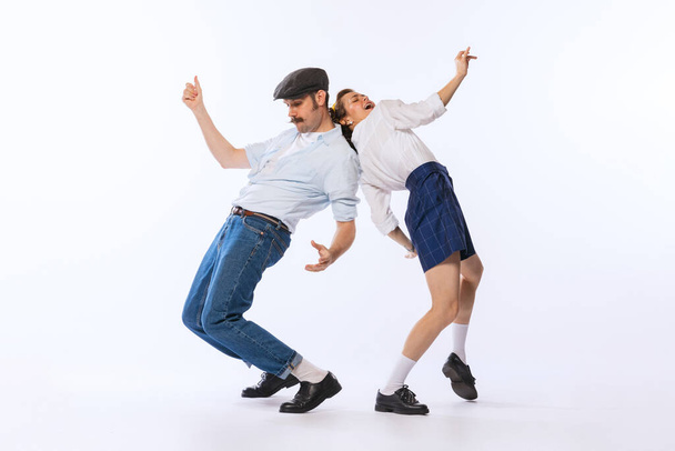 Portrait of young beautiful couple, man and woman, dancing retro dance isolated over white studio background. Vibe . Concept of vintage fashion, hobby, activity, art, music, party, creativity and ad - Fotografie, Obrázek