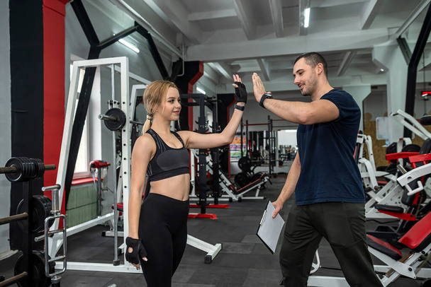 male trainer help her woman client working with dumbbell weights at  gym. active lifestyle - Foto, afbeelding