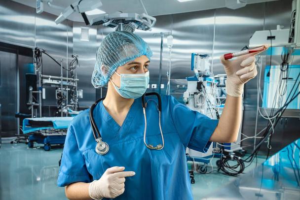 Enfermera en el hospital sosteniendo sangre en tubos de ensayo para su análisis. Trabajo en laboratorio clínico - Foto, Imagen