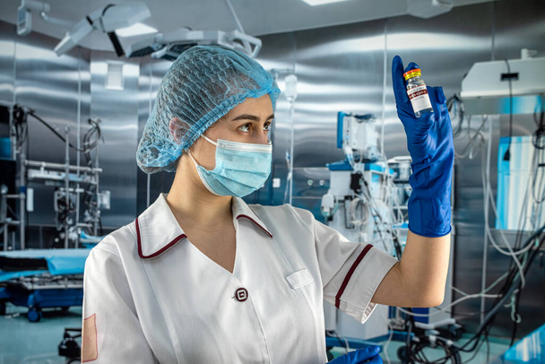 vrouwelijke arts in wit uniform met een beschermend masker en handschoenen bereid zich voor op injectie en zoek naar vaccin  - Foto, afbeelding