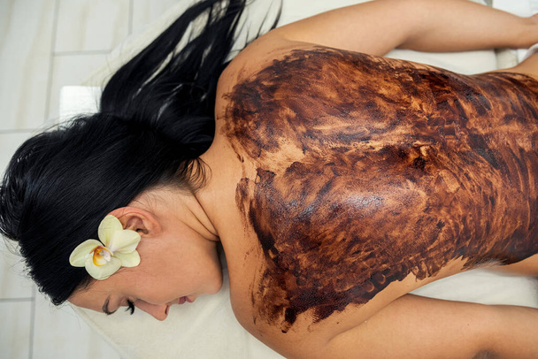 junge Kundin mit Ruhe-Schokolade-Massage im Rücken, gesunder Lebensstil - Foto, Bild