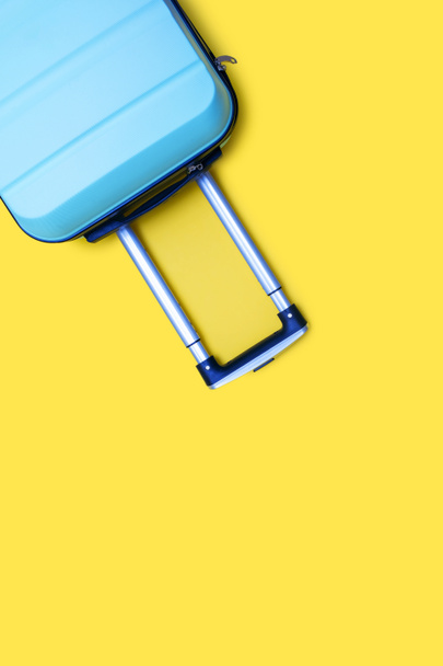 Modrá cestovní taška na žlutém svislém pozadí. Volné místo pro text. Cestovní a rekreační koncept. Ukrajinská národní chuť a myšlenka ukrajinského cestovního ruchu. Stěhování nebo služební cesta - Fotografie, Obrázek