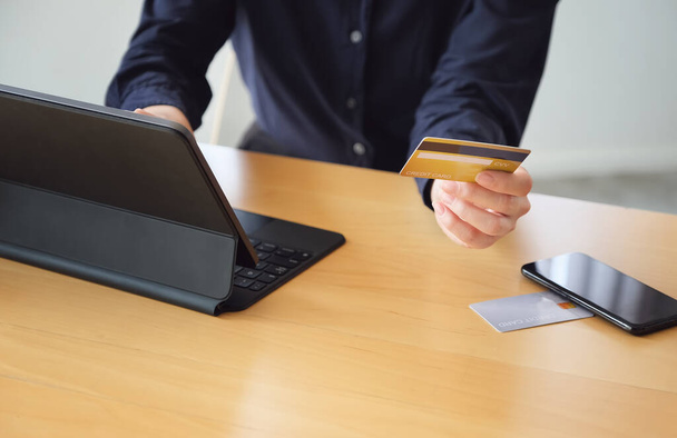 Онлайн-оплата, юні жінки тримають кредитну картку і використовують планшет для онлайн-покупок. - Фото, зображення