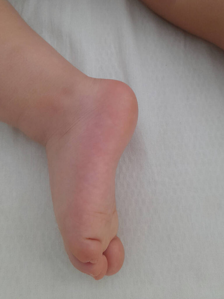 Foot of a baby in his crib while he is sleeping - Valokuva, kuva