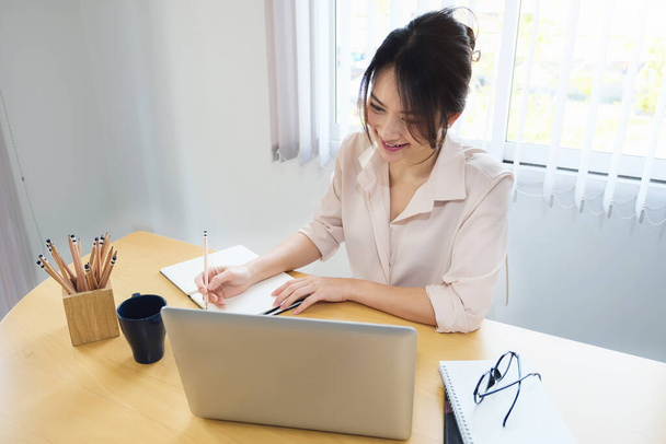 novo normal, uma mulher de negócios usa um computador para trabalhar para uma empresa Via internet em sua mesa em casa. - Foto, Imagem
