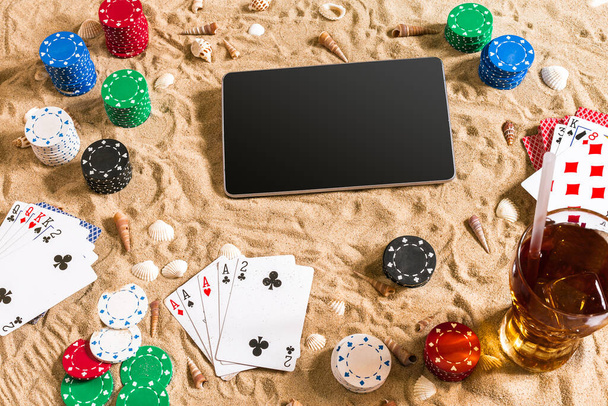 Gioco d'azzardo sul concetto di vacanza - sabbia bianca con conchiglie, fiches da poker colorate e carte. Vista dall'alto. Ricevuto. Estate
 - Foto, immagini