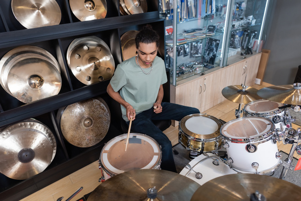 African american customer playing drum set in music store - Photo, Image