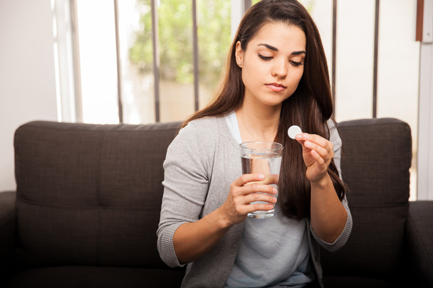 Mulher com pílula e vidro de água
 - Foto, Imagem