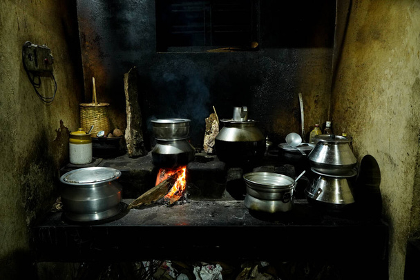 Il cibo è preparato in una vecchia cucina del villaggio con legna da ardere n Kerala con molti utensili - Foto, immagini