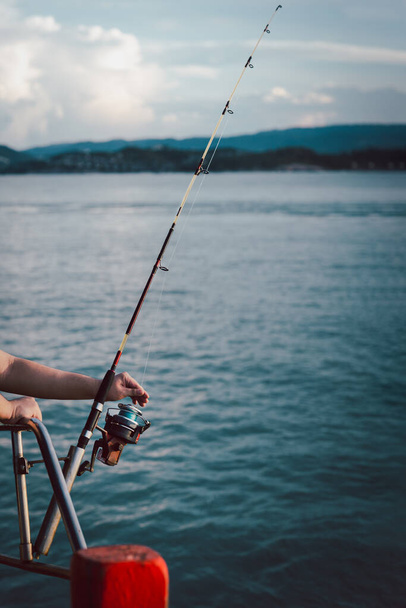 Fishing rod wheel closeup, man fishing from the boat in the sea. - Zdjęcie, obraz