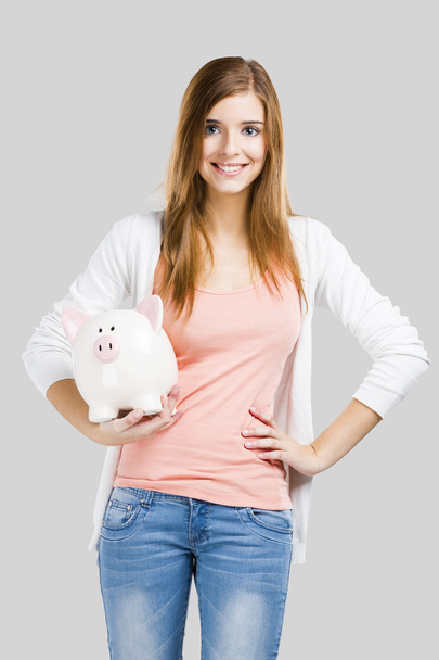 Blonde woman with a piggy bank - Фото, зображення
