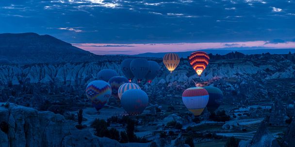 GOREME/TURKEY - June 30, 2022: hot air balloons fly over the city at dawn - Фото, изображение