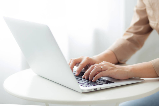 Крупные планы бизнесвумен, работающих за ноутбуком на рабочем столе в домашнем офисе, внештатный поиск и печатание на ноутбуке на столе, образ жизни женщины, изучающей онлайн, бизнес-концепция. - Фото, изображение
