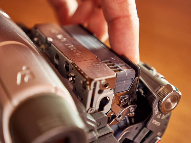 A MiniDV cassette is loaded into the video camera. - Photo, Image