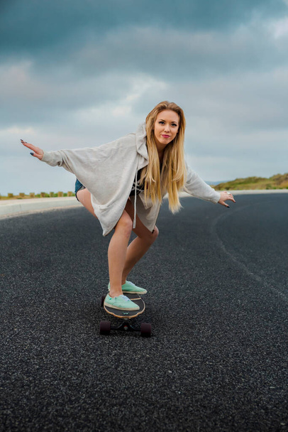 Young woman riding a skateboard - Фото, изображение