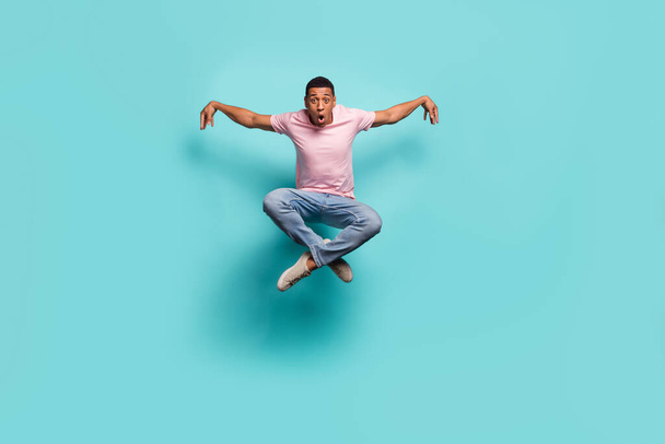 Full length photo of funky cool man dressed pink t-shirt practicing karate jumping high isolated turquoise color background. - Fotografie, Obrázek