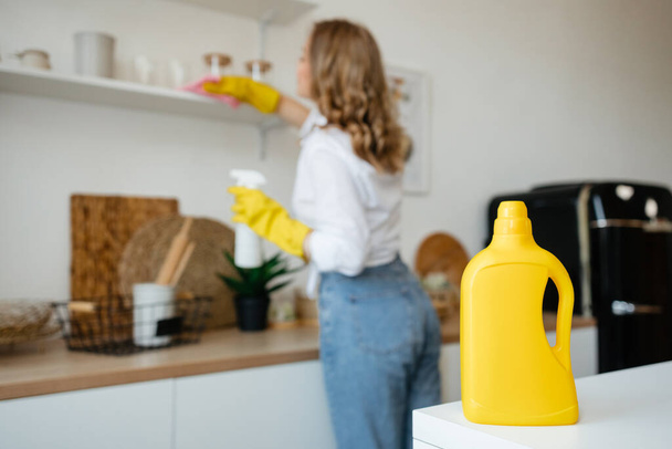 Beautiful girl wipes the shelves in the kitchen. High quality photo - 写真・画像