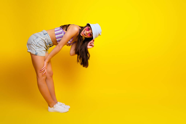 Full length photo of shiny funny girl dressed swimsuit bra cap dark eyewear empty space isolated yellow color background. - Φωτογραφία, εικόνα