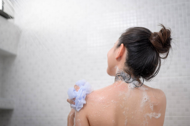 A Happy beautiful woman is taking a shower  - Фото, зображення