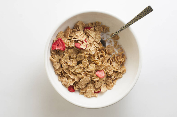 Copos de trigo dulce y fresas Cereal en un tazón con una cuchara - Foto, imagen