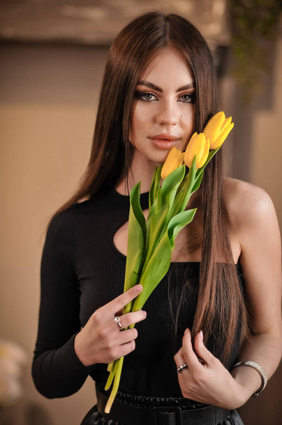 beautiful young woman with tulips in hands - 写真・画像