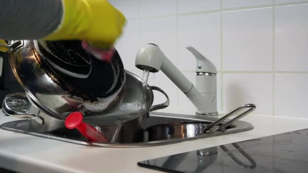 Gedeeltelijk uitzicht op een man die de afwas doet in de keuken thuis. Hoge kwaliteit 4k beeldmateriaal - Video
