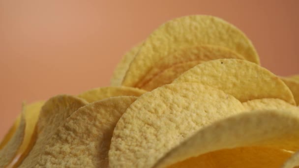 Gebratene Kartoffelchips rotieren auf orangefarbenem Hintergrund. Knusprige Chips. Hochwertiges 4k Filmmaterial - Filmmaterial, Video