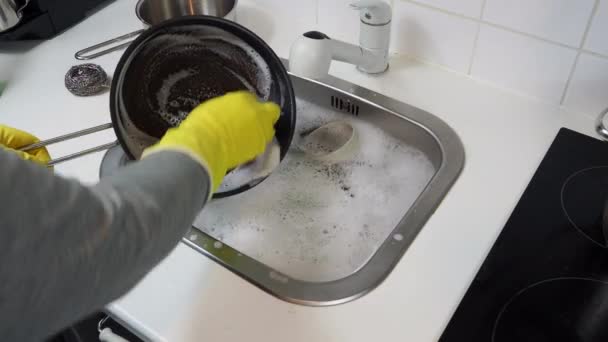 Vista cortada de um homem lavando pratos de pé na cozinha em casa. Imagens 4k de alta qualidade - Filmagem, Vídeo