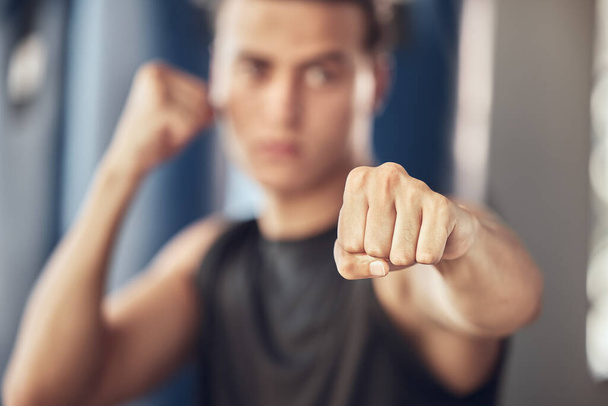 Closeup on the hand of an athlete. Boxer punching in the gym. Strong bodybuilder boxing in the gym. Active fit man throwing a punch in the gym. Strong boxer training in the gym. - 写真・画像