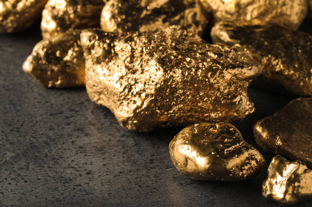 Pile of gold nuggets on grey table, closeup - Foto, Imagem