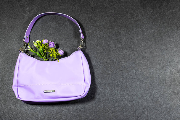 stijlvolle, mode paarse handtas met bloemen op grijze grunge achtergrond - Foto, afbeelding