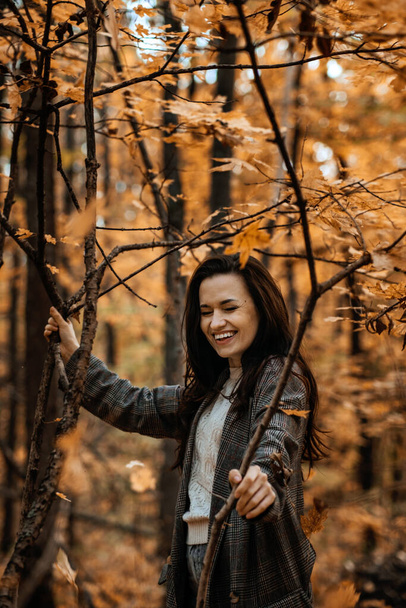 Autumn Anxiety, Seasonal Affective Disorder, Autumn, Winter and Mental Health. Happy brunette woman enjoy life in autumn forest - Photo, Image