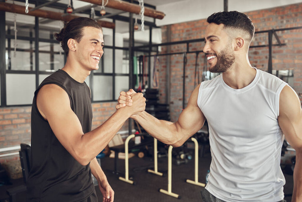 Cheerful athletes greeting each other. Fit bodybuilders collaborate on training together. Strong athletes saying hello in the gym. Confident workout partners make a deal in the gym. - Фото, изображение