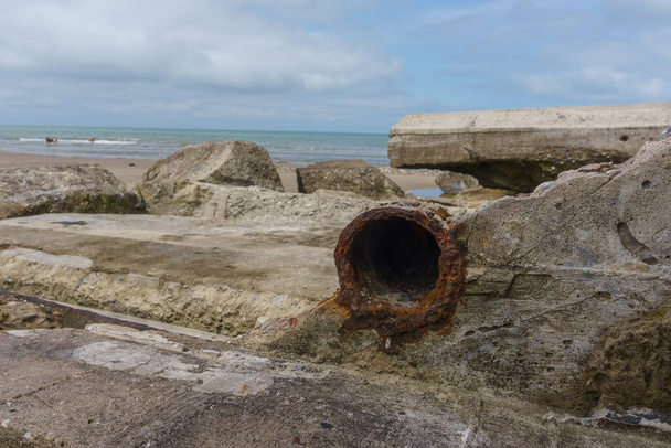 Close up of a rusty iron pipe of an old concrete bunker ruin of the Wehrmacht on beach at Atlantic Wall near Wissant, France - Fotografie, Obrázek