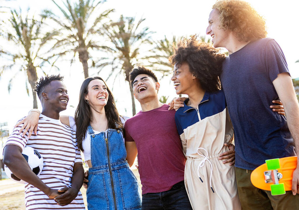 Group of five happy young people standing outside together on vacation - Multiracial friends enjoying summertime on holidays - 写真・画像